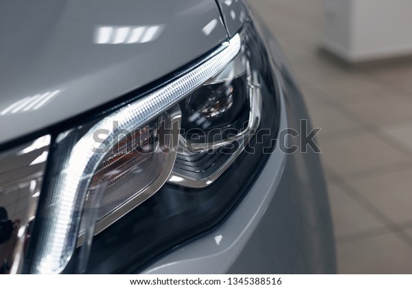 Closeup headlights of a\
modern car. Detail on the front light of a car. Modern and\
expensive car concept