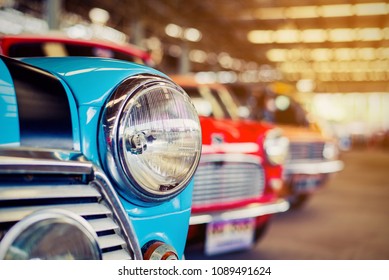 Close-up of headlights of red vintage car in a row. 