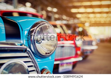 Close-up of headlights of red vintage car in a row. 