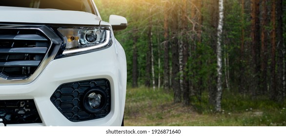 Close-up of headlights of a SUV car in a forest