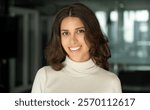 Closeup headshot face portrait of beautiful successful hispanic young business woman looking confident at camera. Smiling latin or eastern middle age female ceo leader businesswoman standing in office