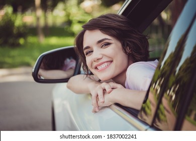 Closeup headshot photo of charming lovely lady cheerful look out of window smiling hands face chin cozy pose rear view mirror watching friend coming car wait wear white shirt indoors