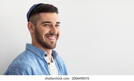 Closeup headshot portrait of casual cheerful jewish guy in yarmulke standing at studio, looking and posing at camera with a smile isolated on white studio background, free copy space, panoramic banner