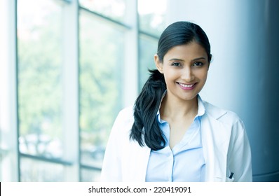 Closeup headshot portrait of friendly, cheerful, smiling confident female, healthcare professional with lab coat. isolated clinic hospital background. Patient visit.