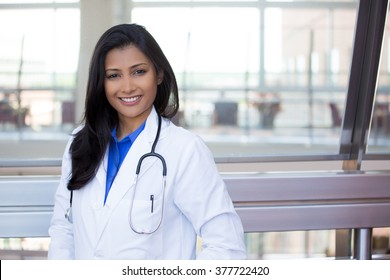 Closeup headshot portrait of friendly, cheerful, smiling confident female, healthcare professional with lab coat. isolated indoor clinic office background. Patient visit.
