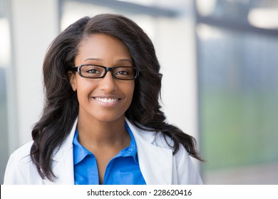 Closeup Headshot Portrait Of Friendly, Smiling Confident Female Healthcare Professional With Lab Coat And Black Glasses. Isolated Hospital Clinic Background. Time For An Office Visit