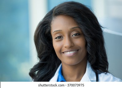 Closeup headshot portrait of friendly, smiling confident female healthcare professional with lab coat and stethoscope. Isolated hospital clinic background. Time for an office visit - Shutterstock ID 370073975