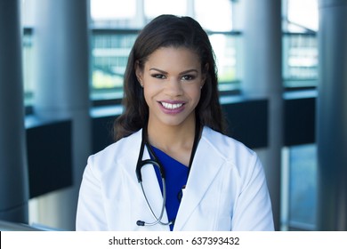 Closeup Headshot Portrait Of Friendly, Smiling Confident Female, Healthcare Professional With Lab Coat, Isolated Indoors Office Background. Patient Visit.