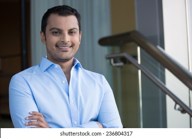 Closeup Headshot Portrait, Happy Handsome Business Man, Smiling, Arms Crossed In Blue Shirt,confident And Friendly On Isolated Office Interior Background. Corporate Success