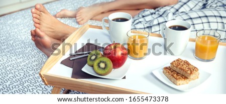 Similar – Image, Stock Photo Healthy breakfast on tray and couple lying in background