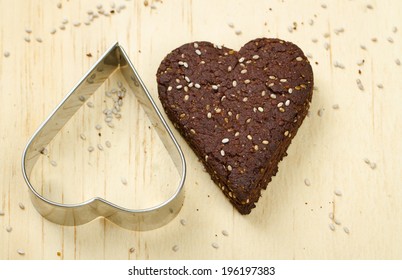 Close-up Of Healthy Dark Chocolate And Chia Seed Cookies On Wooden Background With Cookie Cutter