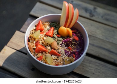 Close-up Of Healthy Food Acai Breakfast Superfoods Smoothie Bowl With Chia Seeds, Bee Pollen, Fresh Strawberry, Apple, Almond And Granola For Healthy Vegan