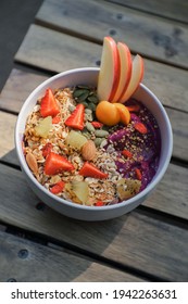 Close-up Of Healthy Food Acai Breakfast Superfoods Smoothie Bowl With Chia Seeds, Bee Pollen, Fresh Strawberry, Apple, Almond And Granola For Healthy Vegan