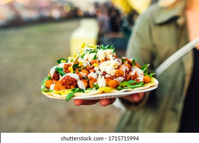 Close-up of healthy vegetarian vegan street food at a street food festival. Pita bread with salad, avocado, cauliflower and chickpeas.
