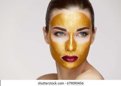 Closeup Of Healthy Young Woman With Gold Cosmetic Face Mask On Soft Skin. 