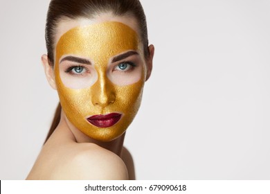 Closeup Of Healthy Young Woman With Gold Cosmetic Face Mask On Soft Skin