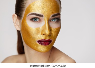 Closeup Of Healthy Young Woman With Gold Cosmetic Face Mask On Soft Skin. 