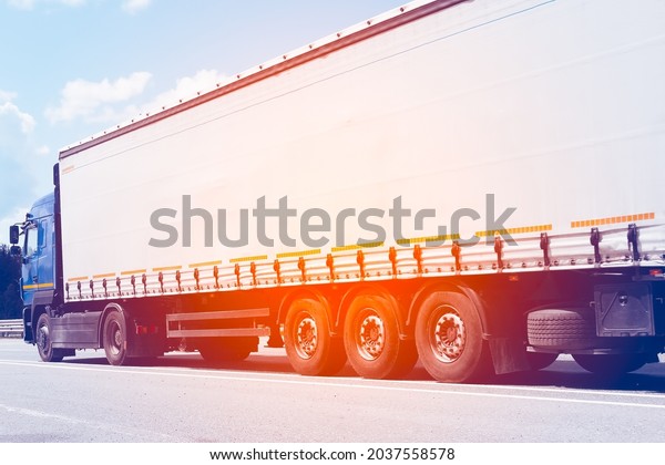 Close-up of a heavy-duty car with a semitrailer\
drives on a motorway on a summer day. Transport logistics for the\
delivery of goods.