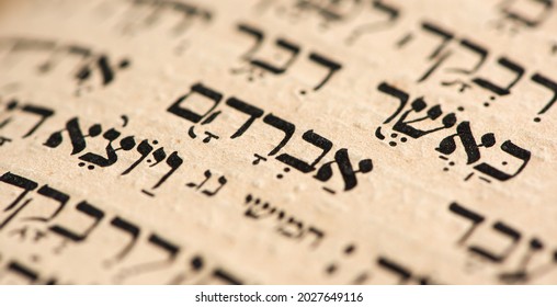 Closeup of hebrew word in Torah page that translates in english as Abraham, common patriarch of religions. Selective focus. Banner