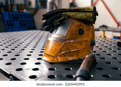 Closeup of the helmet for safe work when grafting, metal table and workshop