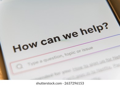 Close-up of a help and support center screen on a smartphone displaying the text How can we help and a search bar. High quality photo