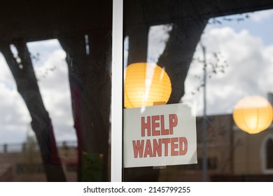 Closeup Of The Help Wanted Sign On The Storefront Window. Small Business Labor Shortage Concept.