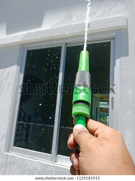 Closeup high pressure water cleaner as seen\
spraying on window