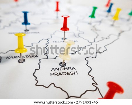 A close-up, high-angle shot of a white map of India, specifically focusing on the southern states. A prominent white pushpin is placed directly on 