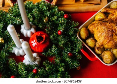 Close-up High-angle View Of Roasted Homemade Thanksgiving Turkey On Christmas Dinner Feast Table With Green Branches Of Xmas Tree, During Holiday Friendly Family Party, No People, Selective Focus.