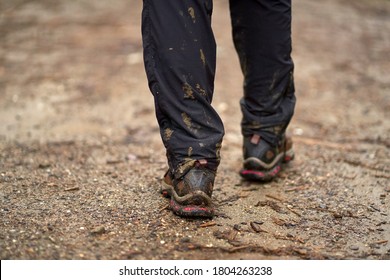 Closeup Of Hiker Legs With Soaked Pants And Muddy Boots On A Trail In The Mountains