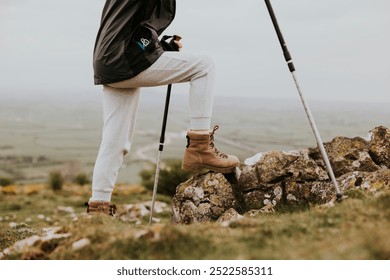 Closeup of hiking leather boots, hiking shoes. Closeup of mountain hiking essentials. Boots and walking sticks essential for mountain nature hike. Outdoor adventure gear. - Powered by Shutterstock