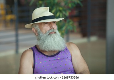 Closeup Of Hipster Old Man With Beard And 
Mustache Wearing Purple Shirt And Straw Fedora Hat.