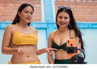 Close-up Of Hispanic Women Dancing Recording Content With A Phone Near The Pool,