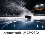 Close-up of a hockey puck falling onto the ice surface at the ice rink. Dramatic scene.