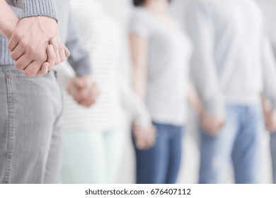 Close-up of holding hands during group psychotherapy session