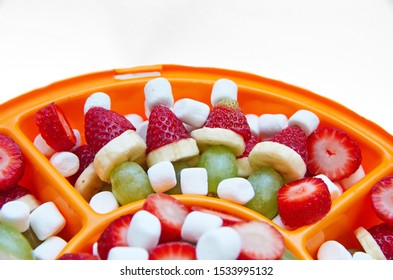 Close-Up Of Holiday Healthy Colorful Fruit Snack For Children; Grinch Fruit (Strawberry, Grape, Banana) Kabobs Surrounded With Marshmallows And Strawberries  