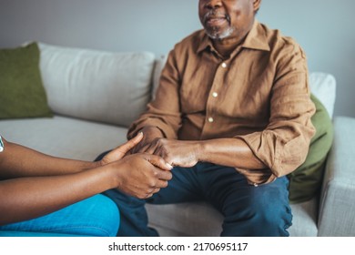 Close-up of home caregiver and senior woman holding hands. Professional Elderly Care. Professional care for elderly at nursing homes. Nurse holding hand of senior man in rest home