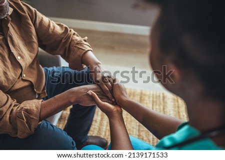 Close-up of home caregiver and senior woman holding hands. Professional Elderly Care. Professional care for elderly at nursing homes. Nurse holding hand of senior man in rest home