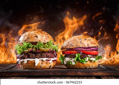 Close-up of home made burgers with fire flames. - Powered by Shutterstock