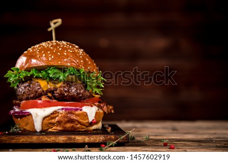 Close-up of home made tasty burger on wooden table.