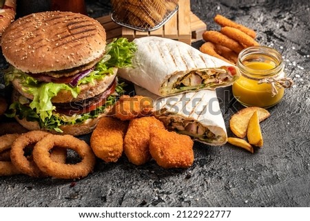 Close-up of home made tasty burger and hot dogs with fried chicken french fries. raditional American food. fast food.