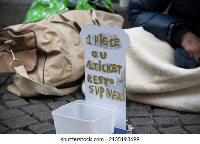 Closeup Of Homeless Placard With Text In French : Un Euro Ou Un Ticket Restaurant Svp Merci, In English : A Euro Or A Restaurant Ticket Please Thank You