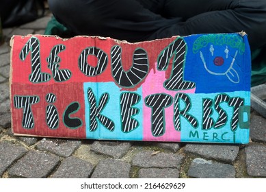 Closeup Of Homeless Placard With Text In French : Un Euro Ou Un Ticket Restaurant Svp Merci, In English : A Euro Or A Restaurant Ticket Please Thank You