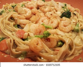 A Close-up Of A Homemade Fettucini Pasta In Alfredo Sauce, With Shrimps, Brocolli And Carrot