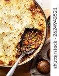 Close-up of homemade sweet potato shepherd’s pie with ground beef, peas, and carrots in a white baking dish. Perfect comfort food for dinner, rustic and hearty meal.
