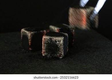 Close-up of hookah tongs and hot coals isolated on a black background. White smoke. Hot coal. Horizontal blurry photo. - Powered by Shutterstock - Get 15% off with code: PIKWIZARD15
