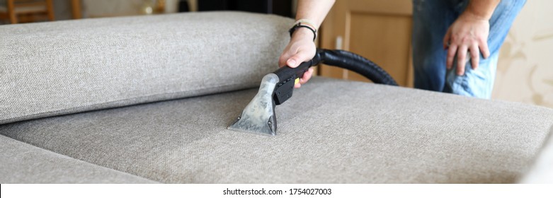 Close-up of hoover for furniture and dirty sofa. Hoovering and cleaning house, housekeeper or special service for house cleanliness maintenance. Washing fabric cloth