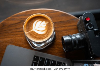 Close-up of Hot coffee latte with latte art milk foam in cup mug and camera, laptop computer on wood desk office desk in coffee shop at the cafe,during business work concept - Powered by Shutterstock