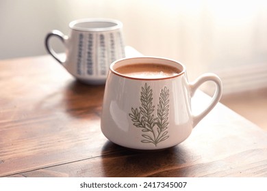 Close-up hot coffee in the morning on wooden table. Two ceramic coffee mugs with smoke on old wooden table. Hot Coffee Drink Concept - Powered by Shutterstock