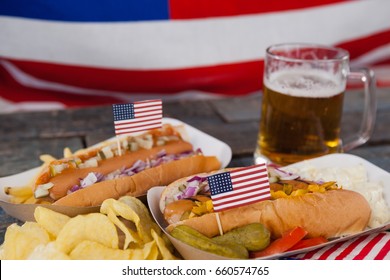 Close-up of hot dog and glass of beer with american flag on wooden table - Powered by Shutterstock